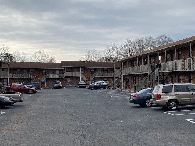 a parking lot filled with cars in front of a building