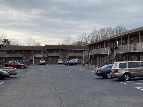 a parking lot filled with cars in front of a building
