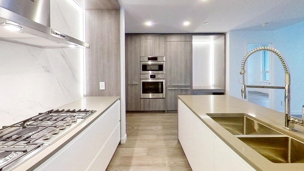 the kitchen has stainless steel appliances and white countertops