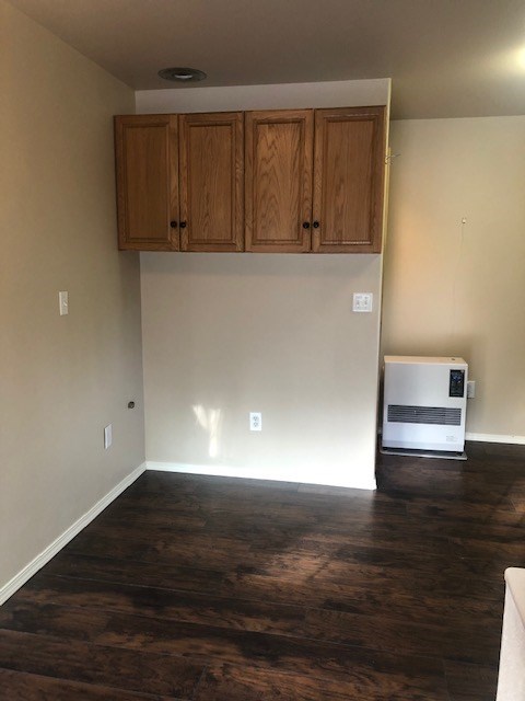 an empty living room with wooden floors and cabinets