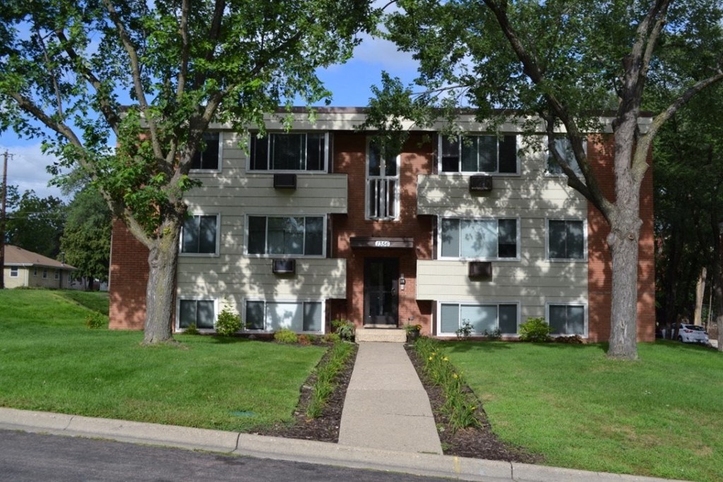 an apartment building with a sidewalk in front