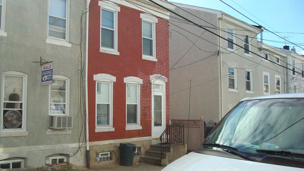 A red brick building with a sign that says "For Rent" on the left side.