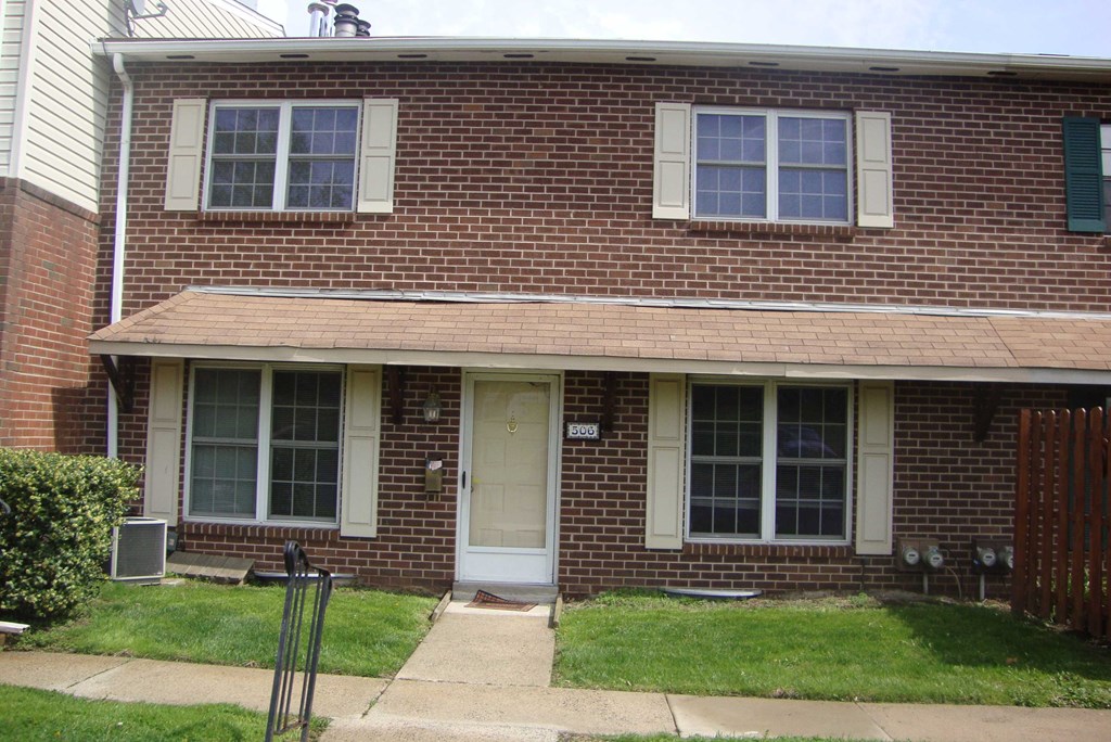 the front of a brick house with a white door