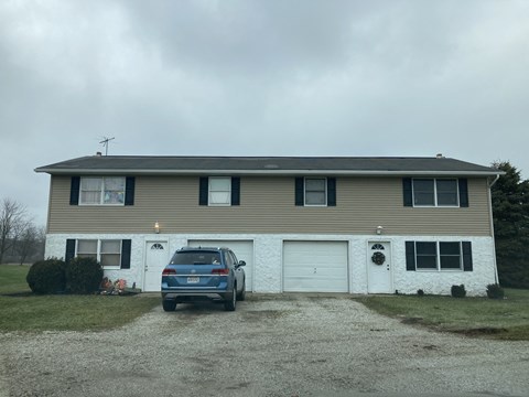 A house with a car parked in front of it.