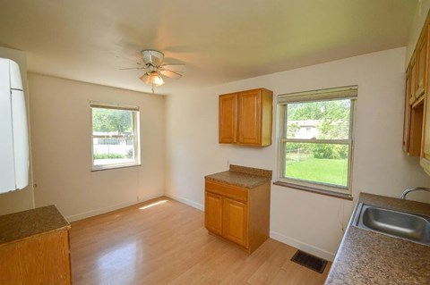 A kitchen with wooden cabinets and a ceiling fan.