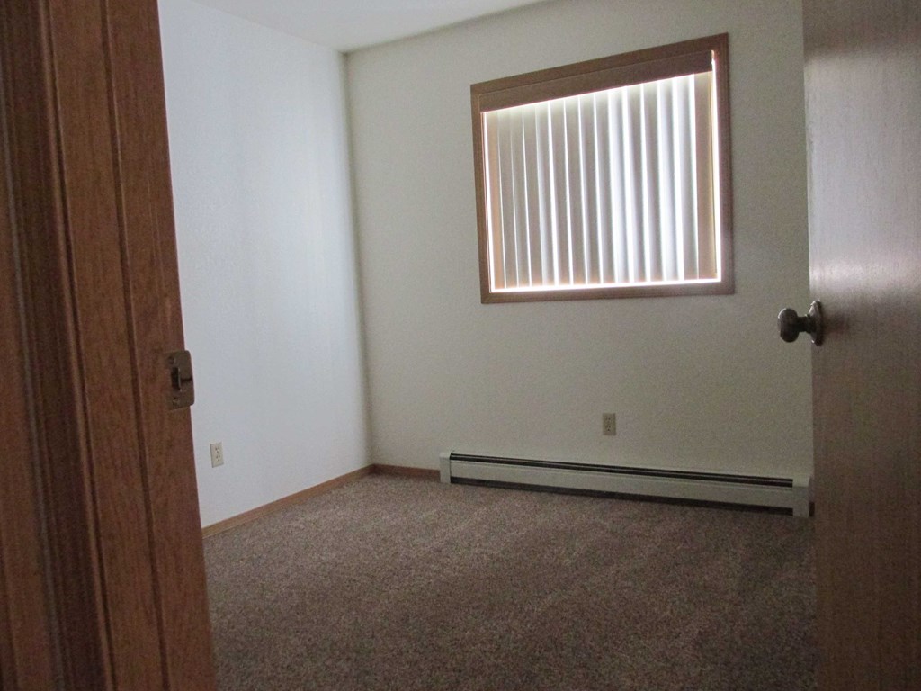 an empty room with a window and a door