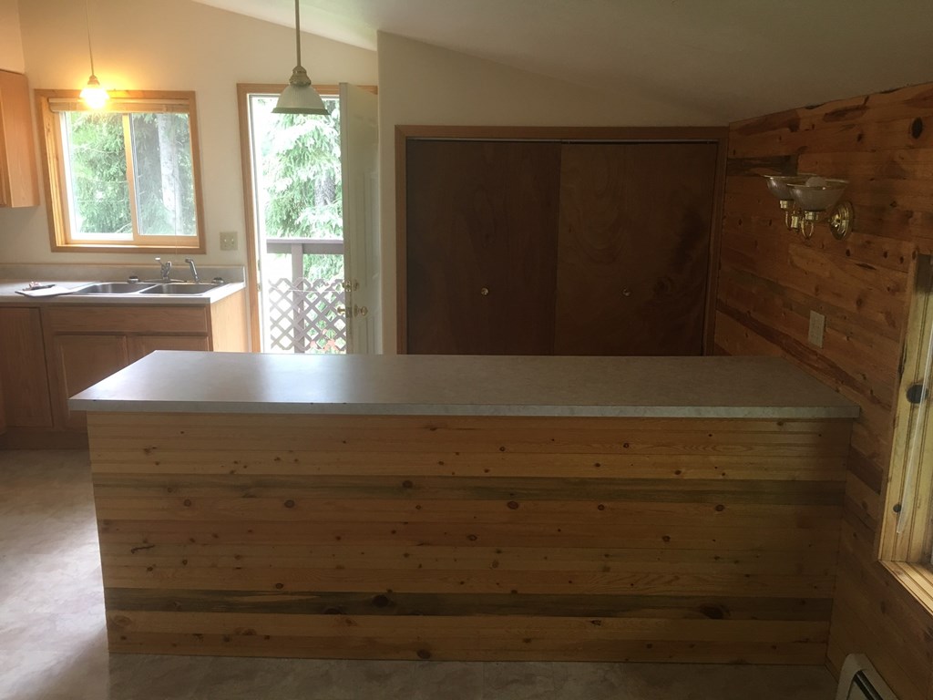 a kitchen with a bar in the middle of a room