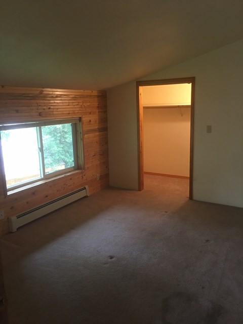 an empty living room with a window and a door