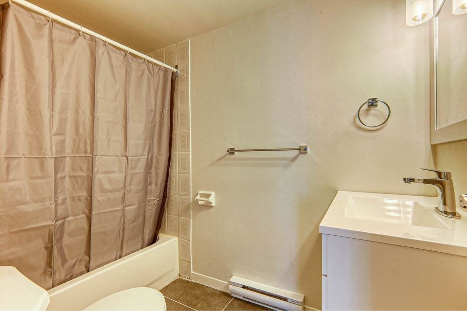 a bathroom with a shower and a sink and a toilet