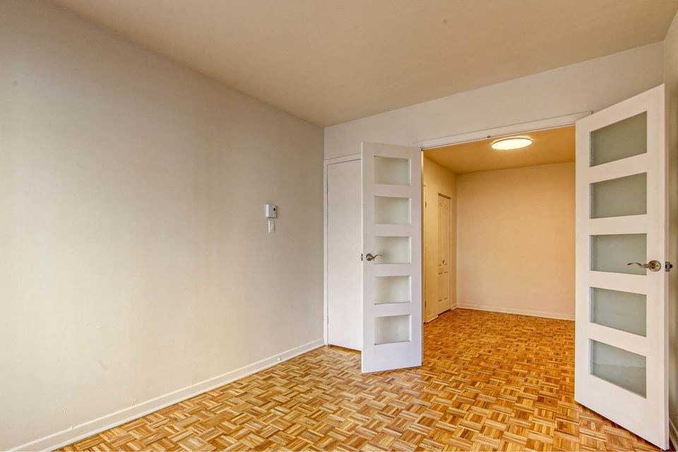 an empty room with an open door to a closet