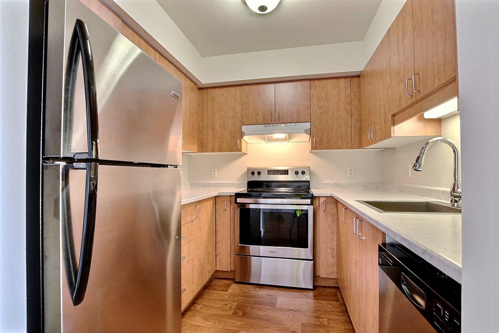 a kitchen with wooden cabinets and stainless steel appliances