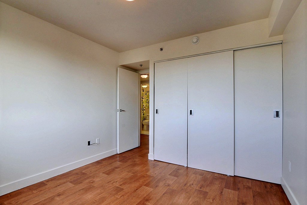 a bedroom with two closets and a hard wood floor