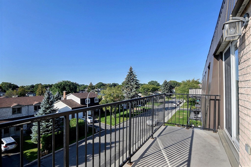 a balcony with a view of a yard and a building