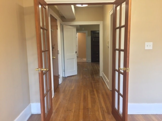 A hallway with wooden floors and white walls.