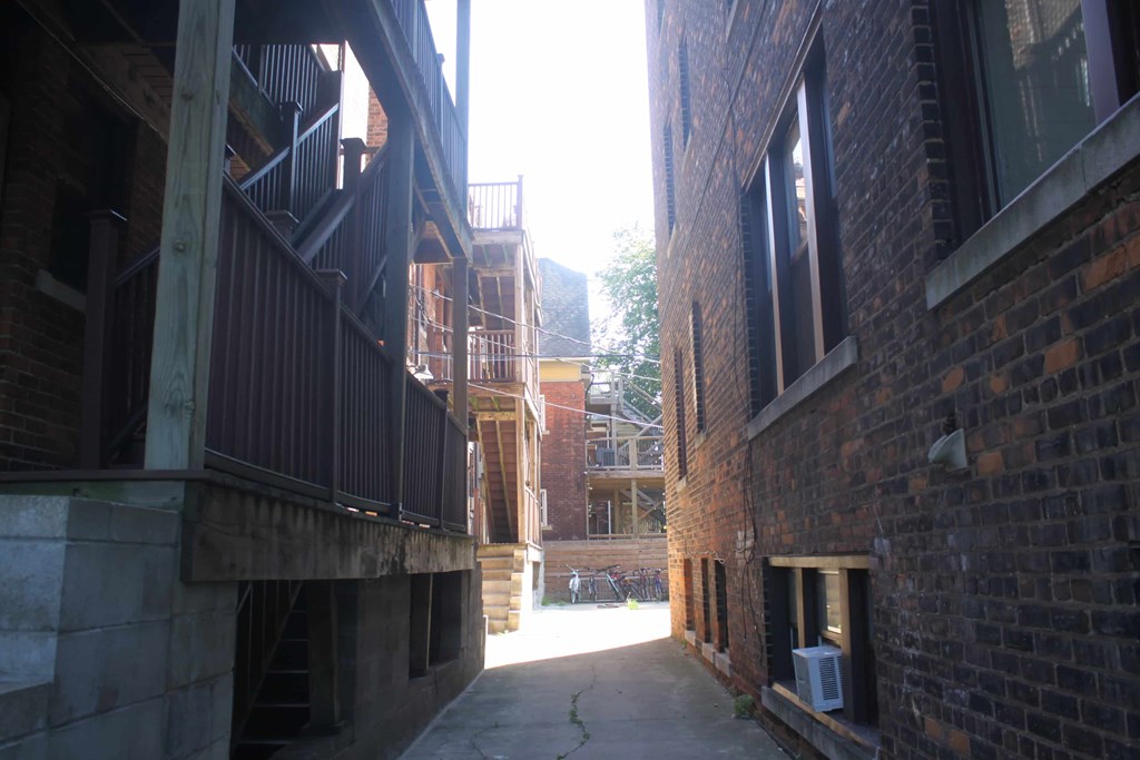 A narrow alley between two buildings with a window on the right.