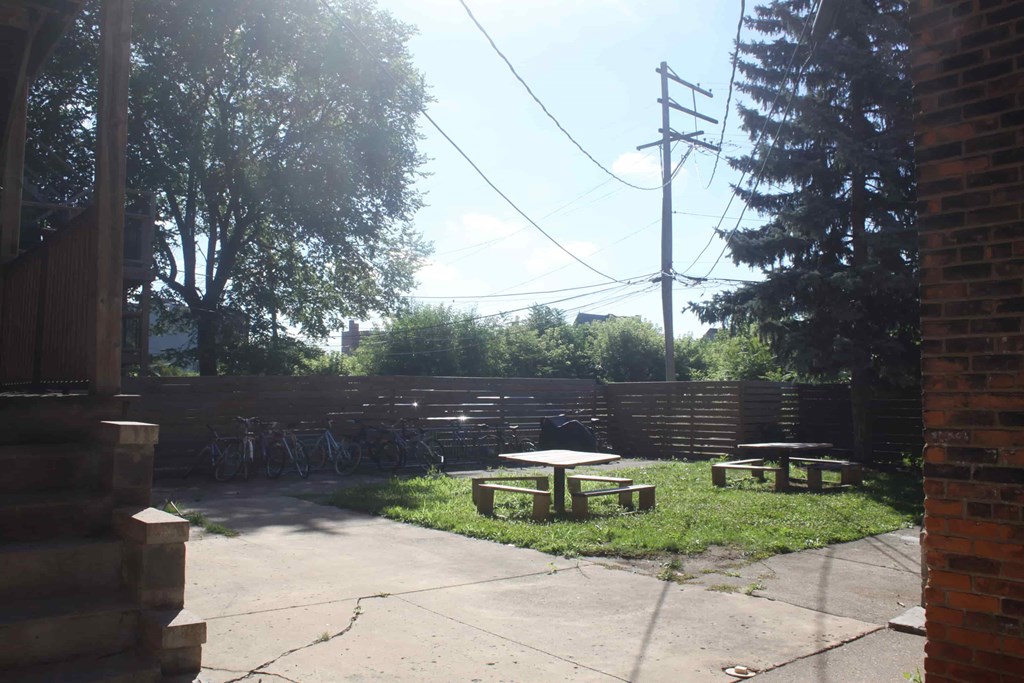 A sunny day in a courtyard with picnic tables and bicycles.