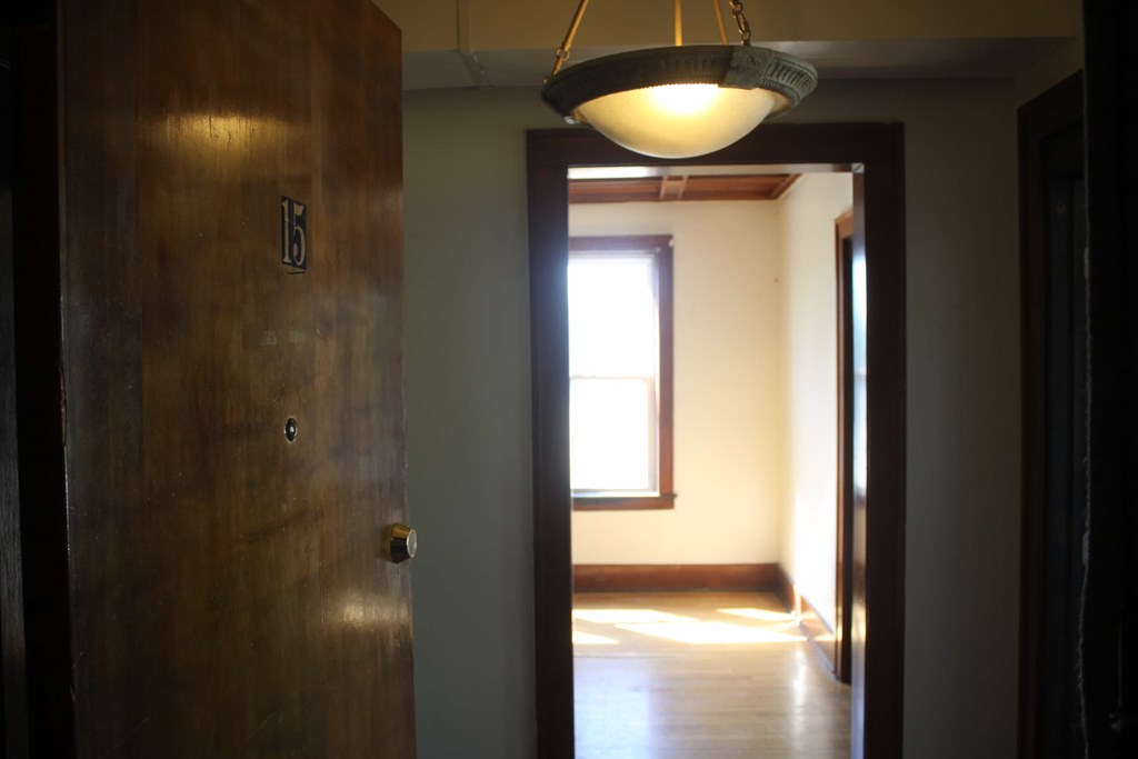 A brown door with a light hanging above it.