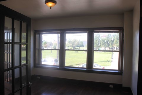 A room with a view of a green lawn through the window.