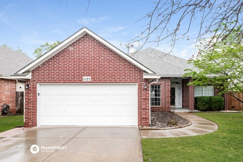 a white garage door in front of a brick house