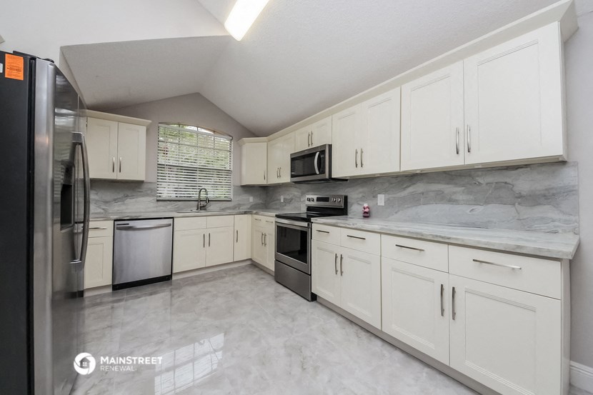 a kitchen with white cabinets and stainless steel appliances