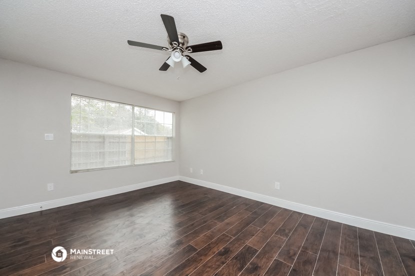 the living room of our studio apartment atrium with wood flooring and ceiling fan