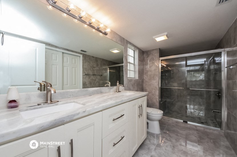 a bathroom with a sink and a shower and a toilet