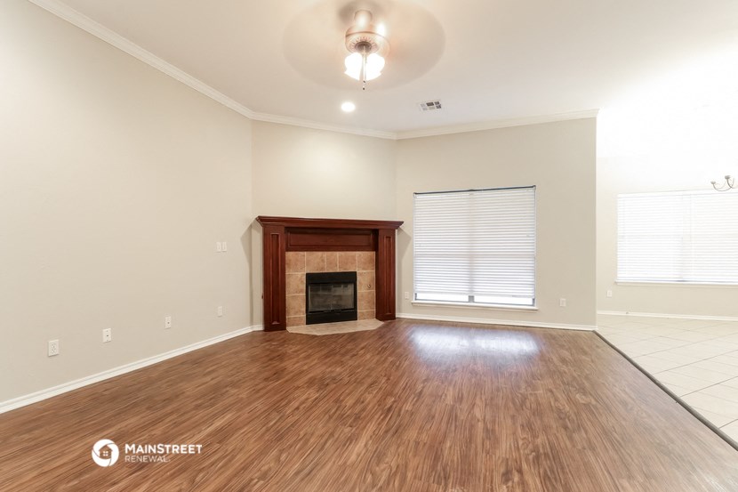 the living room with wood flooring and fireplace