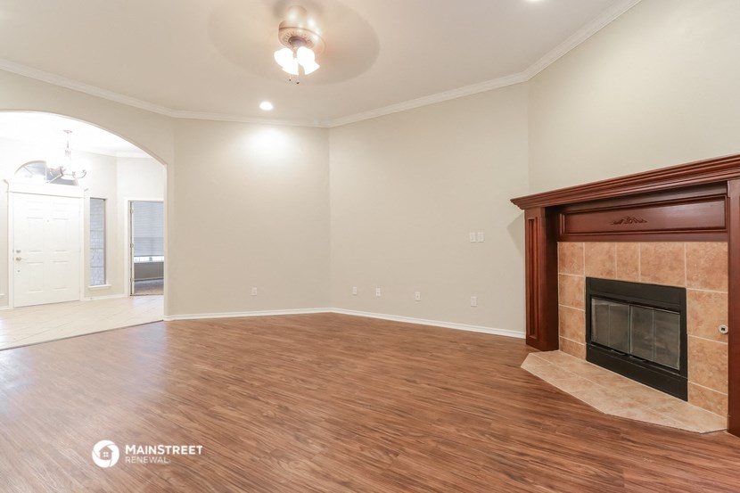 the living room with fireplace and wood flooring