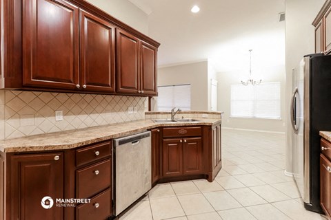 a kitchen with wooden cabinets and a sink and a refrigerator