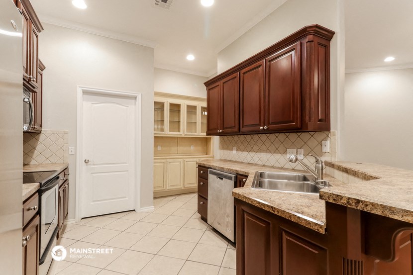 a kitchen with granite counter tops and wooden cabinets