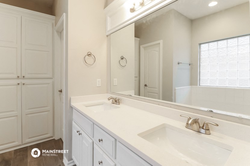a white bathroom with two sinks and a large mirror
