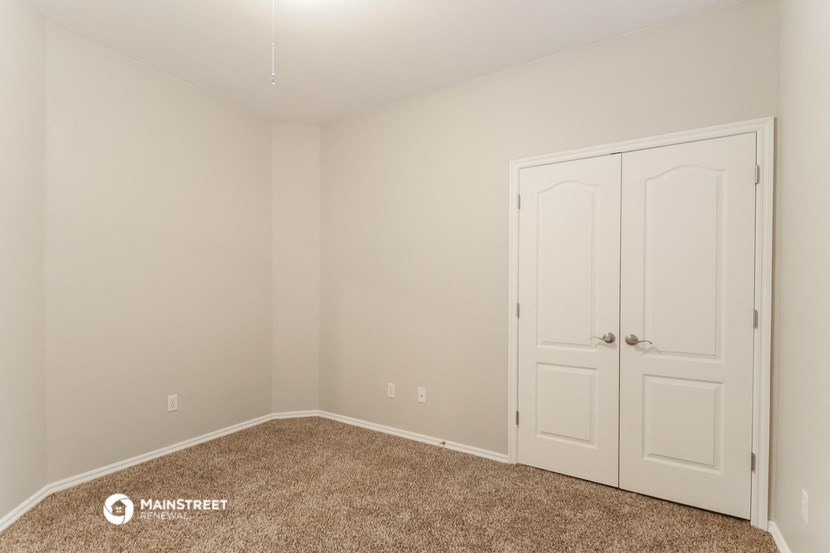 a bedroom with two closets and a carpeted floor