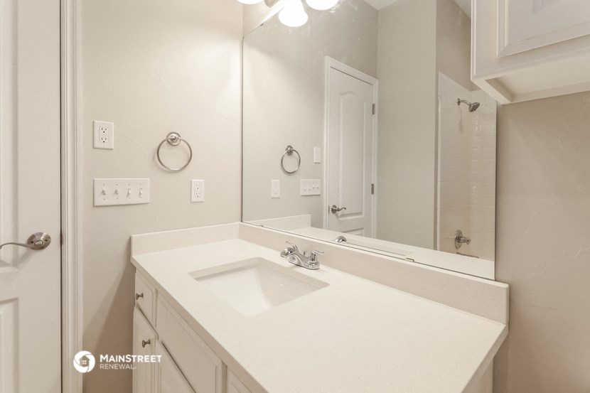 a white bathroom with a sink and a mirror