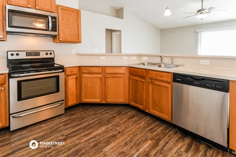 a kitchen with wooden cabinets and stainless steel appliances