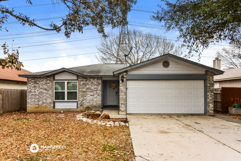a brick house with a white garage door and a driveway