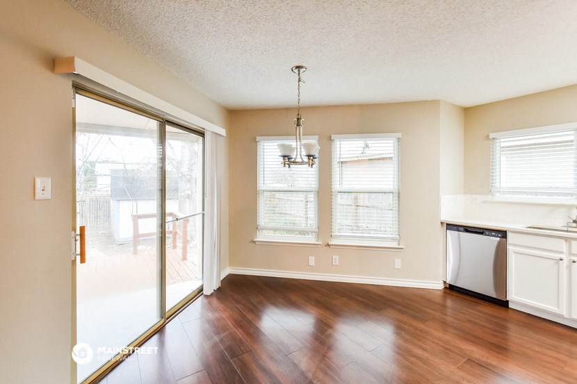 an empty kitchen and living room with a sliding glass door to a patio