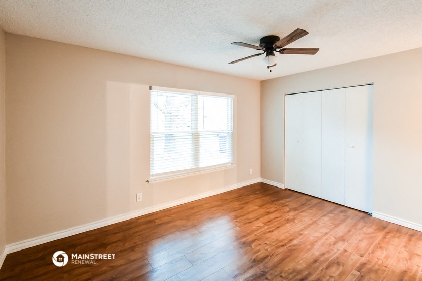 an empty room with a ceiling fan and a window
