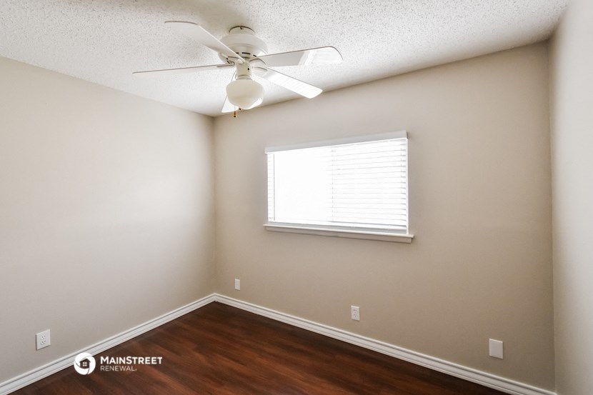 a bedroom with a ceiling fan and a window