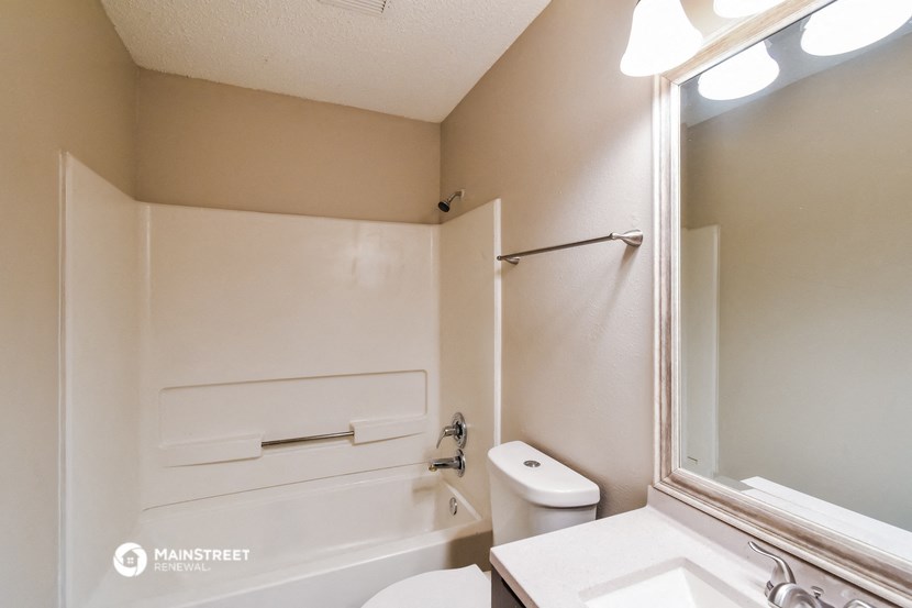 a bathroom with a toilet and a sink and a bath tub