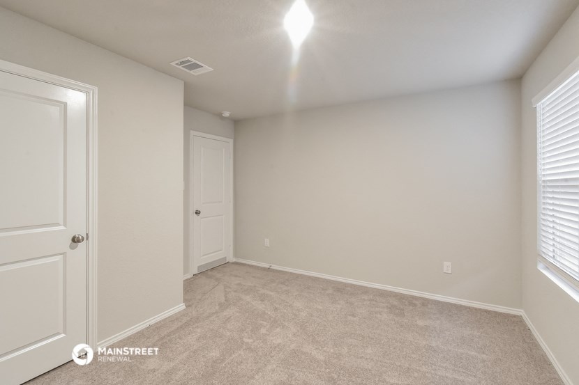 the spacious living room with a closet and a door to the bedroom