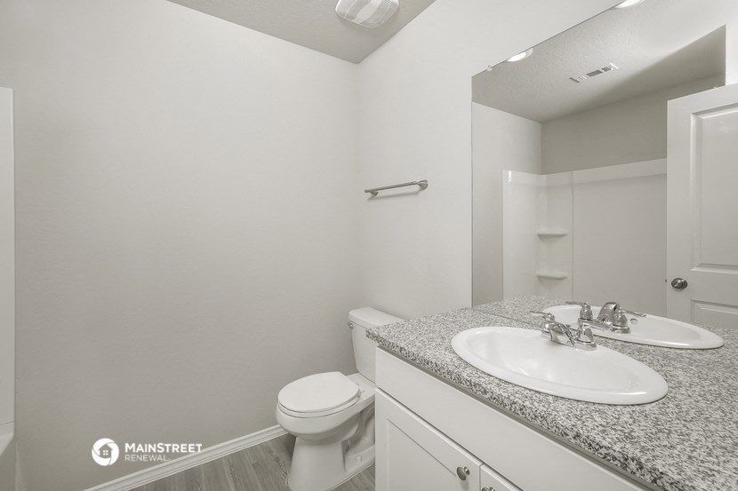 a bathroom with a sink and toilet and a mirror