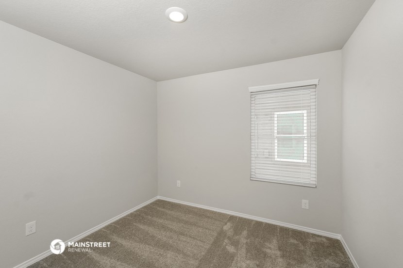 the interior of a small room with carpet and a window