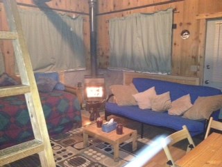 A room with a blue couch and a wooden table.