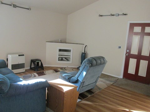 A living room with a blue couch and a grey armchair.