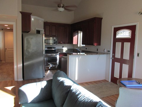 A kitchen with a refrigerator and a couch.