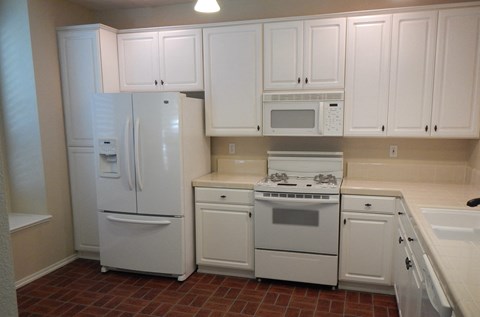 a kitchen with white appliances and white cabinets