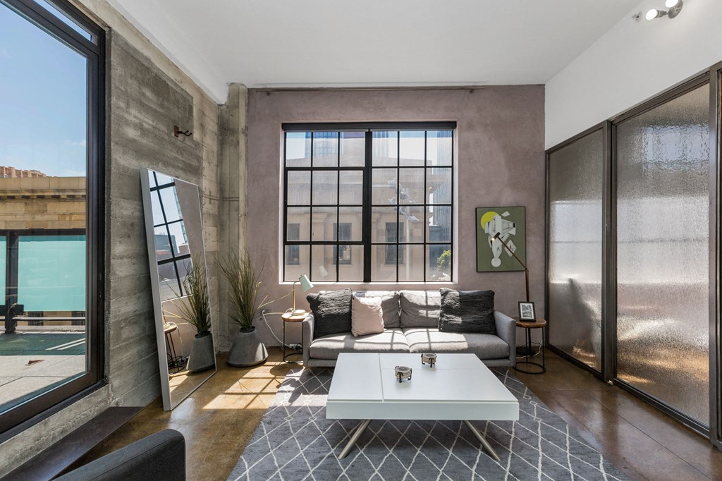 a living room with a large window and a couch and a coffee table