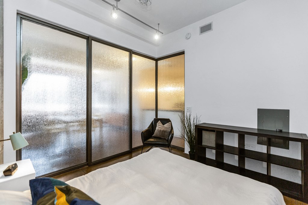 a bedroom with a large bed and a large window