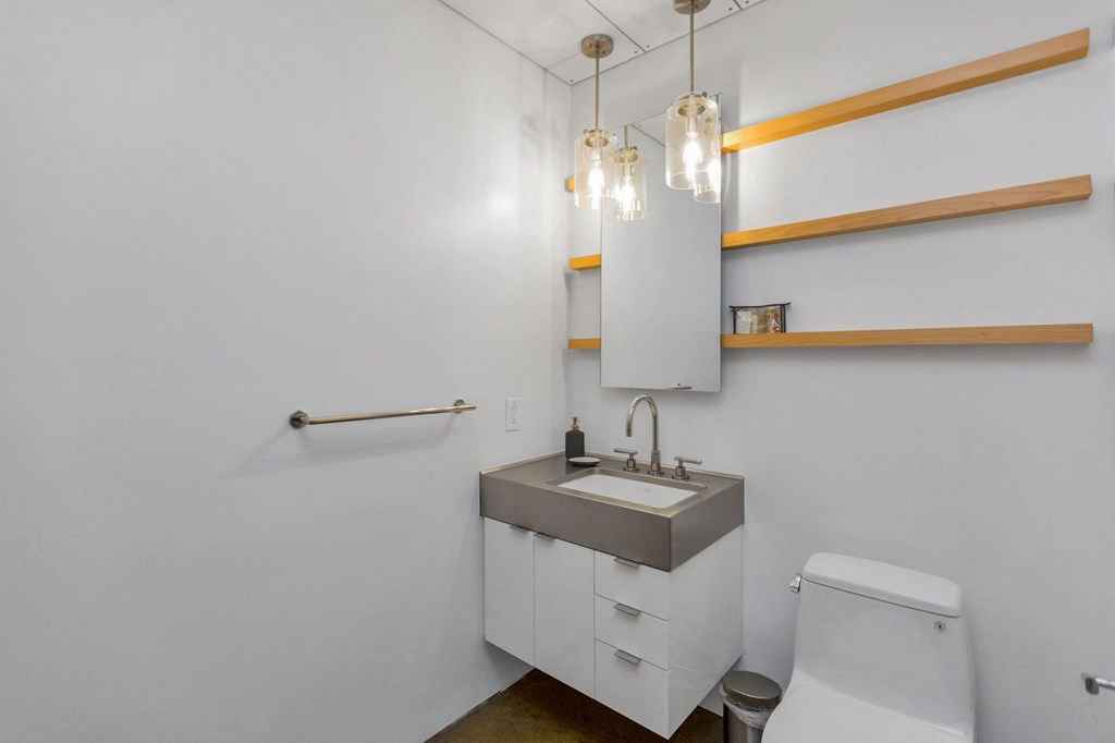 a bathroom with white walls and a sink and a toilet