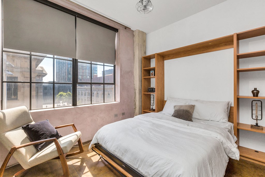 a bedroom with a bed and a large window